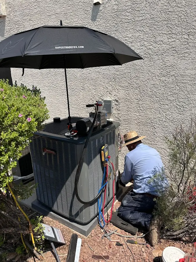 HVAC technician performing outdoor AC maintenance in Artesia