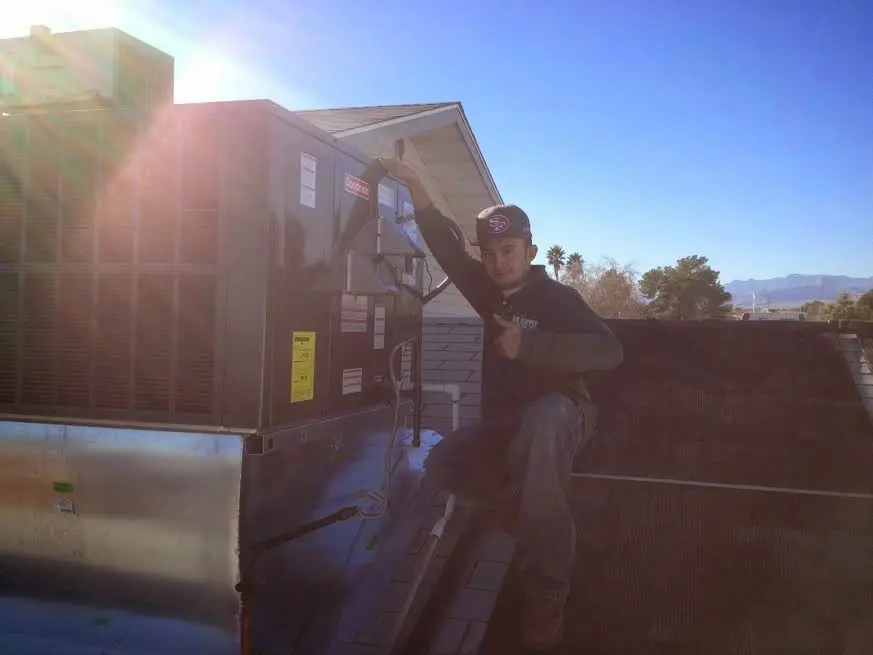 HVAC technician performing HVAC Inspection on a rooftop unit in Artesia